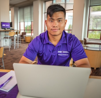Student on laptop in Curris Business Building's student lounge. 